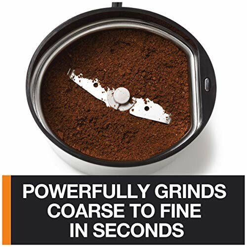 Coffee grinder with ground coffee and blade.