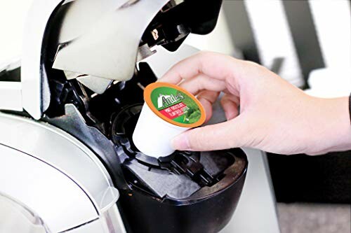 Person placing coffee pod in machine.