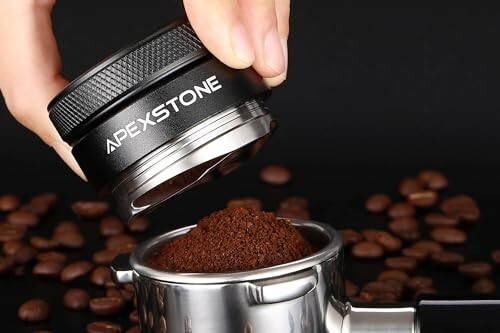 Hand holding coffee tamper over portafilter with coffee grounds