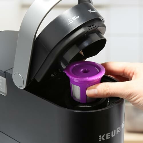 Hand placing reusable pod in Keurig coffee maker.